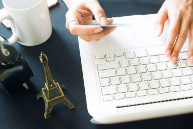 Kadının ellerini kullanarak dizüstü bilgisayar ve kredi kartı, iş ve seyahat konsepti