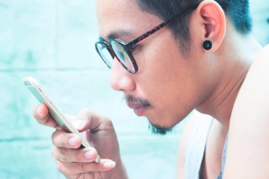 Asya smartphone vasıl, ciddi seyir gözlüklü adam sakallı yüzü dijital aracı 