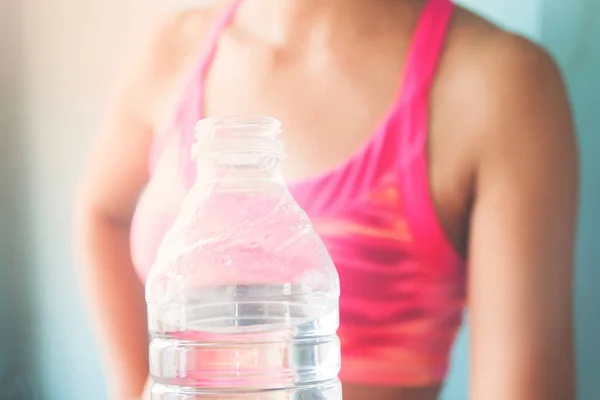 Gros plan sur bouteille d'eau avec femme sportive floue en arrière-plan, Style de vie sain — Photo