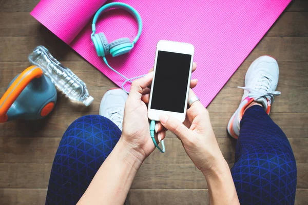 Blickwinkel auf sportliche Frau mit Fitnessgeräten mittels Smartphone, Ernährung und Fitness, gesundes Lebensstilkonzept — Stockfoto