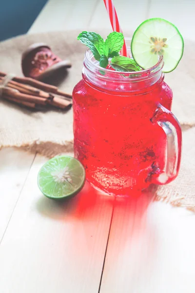 Bebida fria de cor vermelha com limão fatiado, bebida de verão — Fotografia de Stock