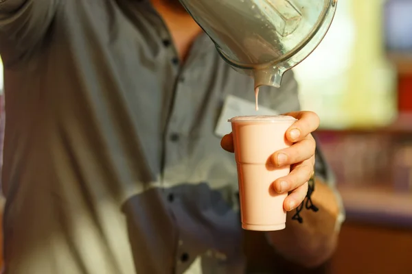 The hand of the bartender, pours the milkshake — Stock Photo, Image