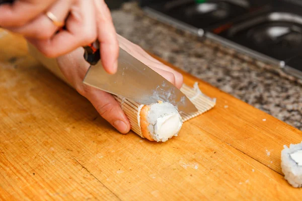 Snijden sushi rolt. — Stockfoto