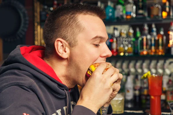 Joven comiendo una hamburguesa — Foto de Stock