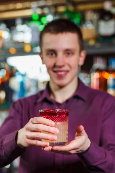 Cheerful bartender gives the cocktail to customer. — Stock Photo, Image