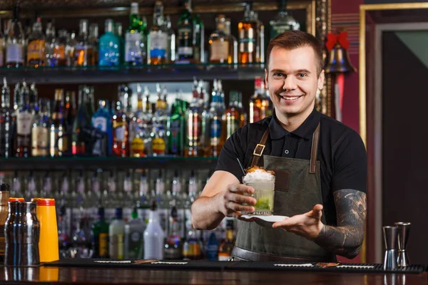 Cheerful bartender gives the cocktail to customer. — Stock Photo, Image