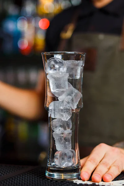 Highball glass with ice standing on bar counter — Stock Photo, Image