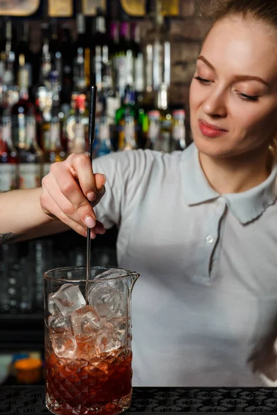 Женщина-бармен делает алкогольный коктейль — стоковое фото