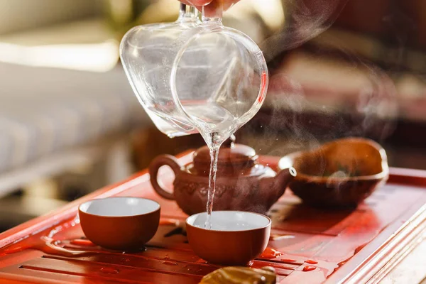 De thee ceremonie. Vrouw giet de thee in een kom met thee. — Stockfoto