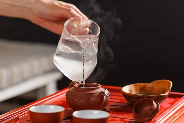 De thee ceremonie. De vrouw giet heet water in de theepot — Stockfoto