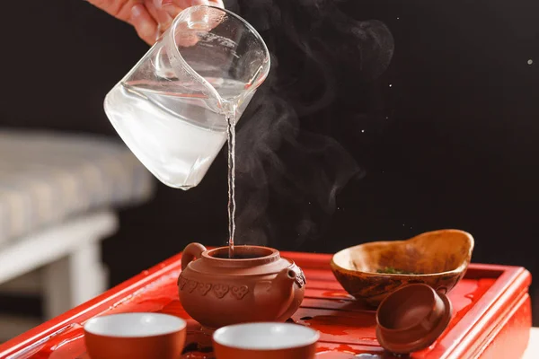 De thee ceremonie. De vrouw giet heet water in de theepot — Stockfoto