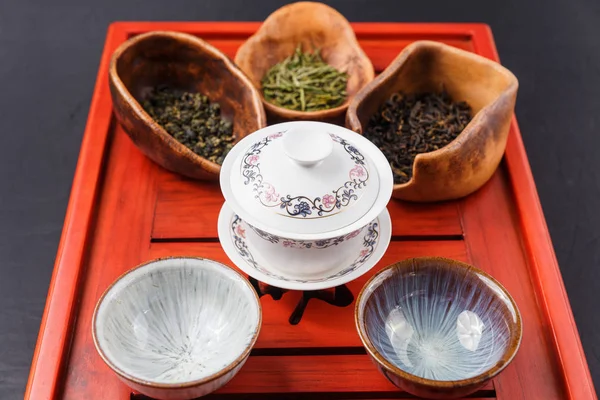 Set of teapot, three kinds of tea and four bowls — Stock Photo, Image