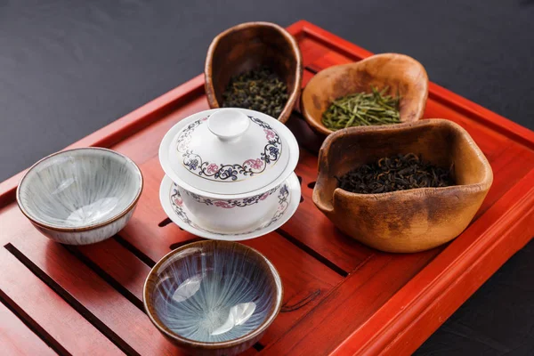 Set of teapot, three kinds of tea and four bowls — Stock Photo, Image