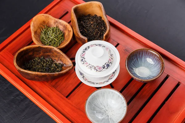 Набор чайник, три вида чая и четыре чашки — стоковое фото
