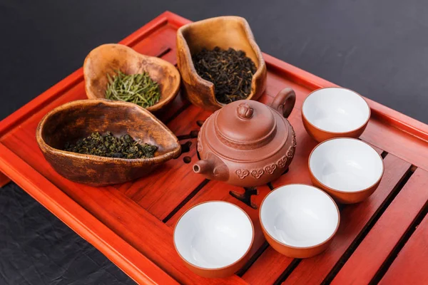 Set of teapot, three kinds of tea and four bowls — Stock Photo, Image