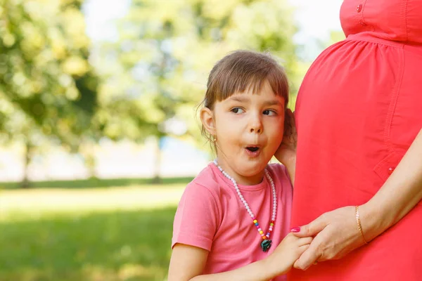 Mladá krásná těhotná žena s dcerou malé roztomilé — Stock fotografie