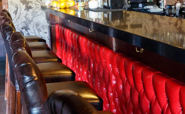 Ряд красных стульев возле барной стойки — стоковое фото