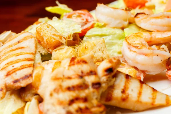 Contexto da salada de alface romaine com camarão, salmão esfumado, croutons, frango grelhado, tomate cereja com molho de césar e parmesão ralado — Fotografia de Stock