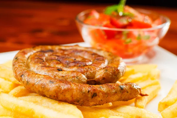 Saucisse grillée au feu avec frites et salade de tomates — Photo