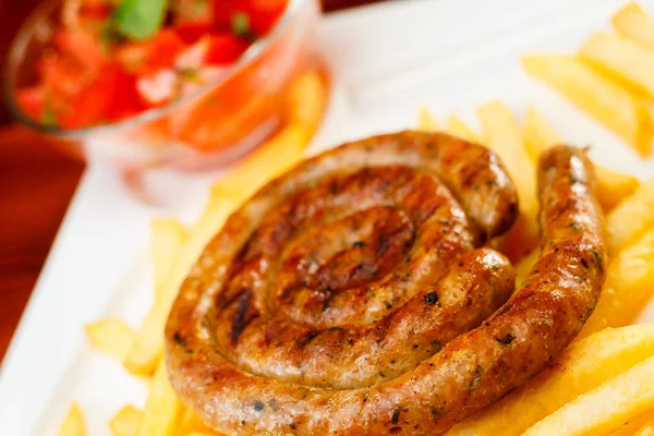 Fire grilled sausage with fries and tomato salad — Stock Photo, Image