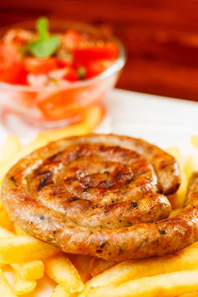 Saucisse grillée au feu avec frites et salade de tomates — Photo