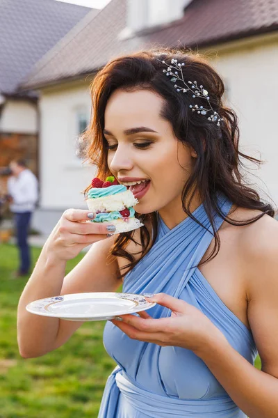 Niedliche Brautjungfer isst Hochzeitstorte — Stockfoto