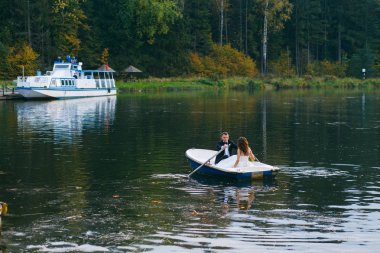 Gelin ve damat göl kenarında bir kayığın içinde