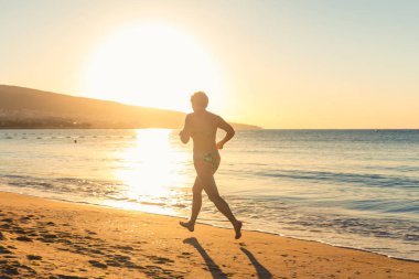 Eldery bir kadın açık havada sabah sahilde koşu
