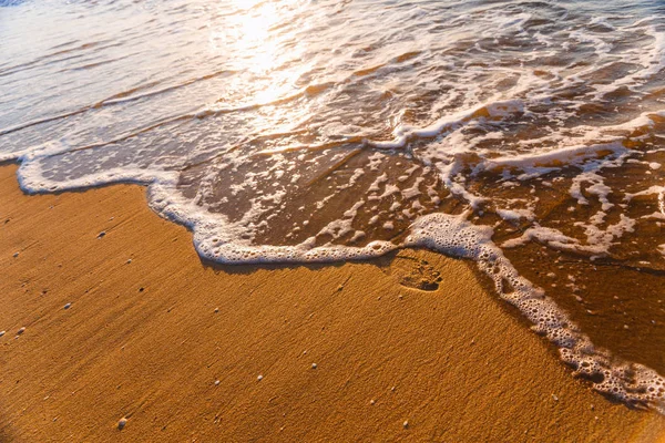 Pláž, vlna a kroky při západu slunce — Stock fotografie