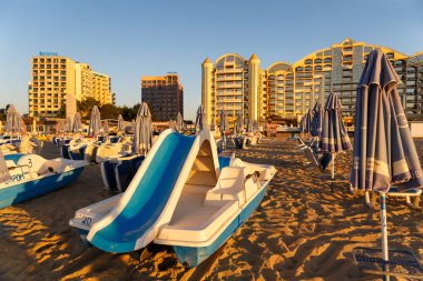 Plaj şemsiyeleri ve bir plajda şezlong