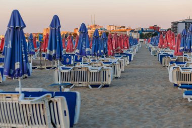 Plaj şemsiyeleri ve bir plajda şezlong