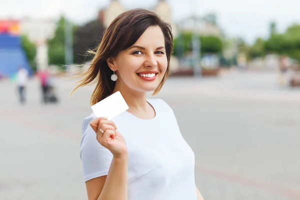 Joven hermosa mujer sosteniendo la disposición de la tarjeta bancaria — Foto de Stock