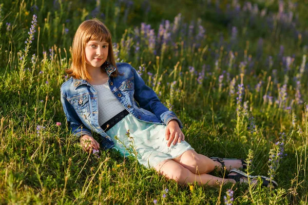 Beautiful young girl lying among the flowers — Stock Photo, Image