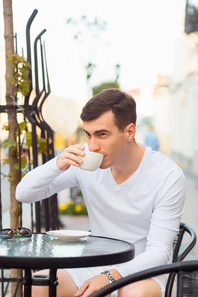 Junger schöner Mann trinkt Kaffee — Stockfoto