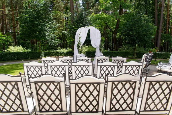 Λευκές καρέκλες σταθεί στις γραμμές πριν από το βωμό του γάμου — Φωτογραφία Αρχείου