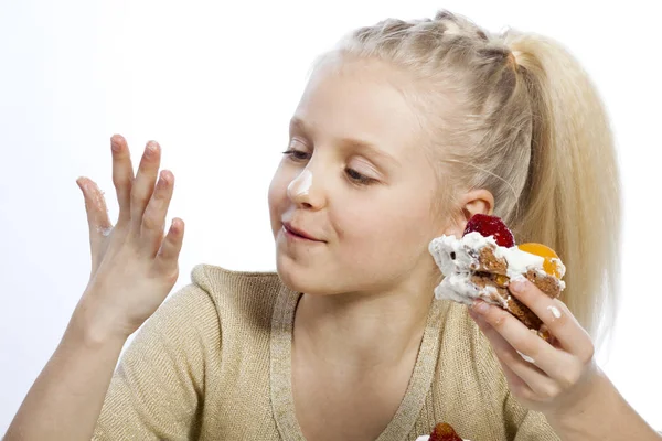 Mädchen isst einen Kuchen — Stockfoto