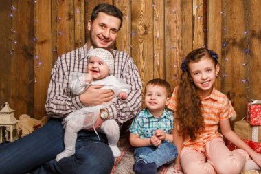 Baba ile çocuklar Noel fotoğraf oturumunda