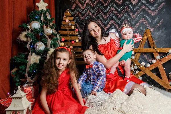 Mãe com crianças em uma sessão de fotos de Natal — Fotografia de Stock