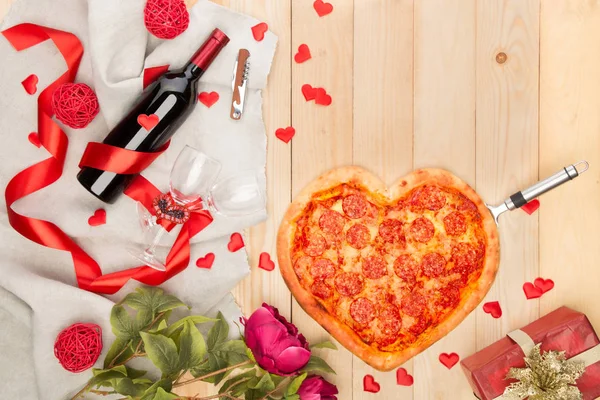 Pizza italiana en forma de corazón con pepperoni y mozzarella y botella de vino tinto —  Fotos de Stock