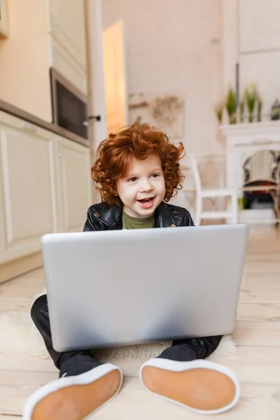 Pequeño pelirrojo utiliza un ordenador portátil — Foto de Stock