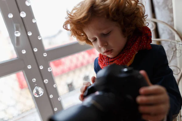 Красивый рыжий мальчик с камерой в руках — стоковое фото
