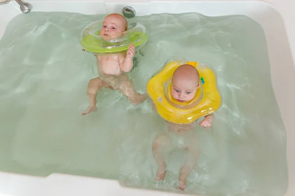 Newborn twins swimming in the bath — Stock Photo, Image