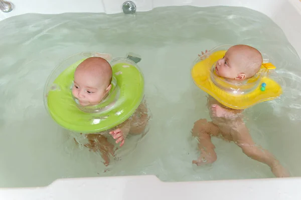 Newborn twins swimming in the bath — 图库照片