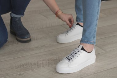 Kot pantolon ve beyaz spor ayakkabılar.