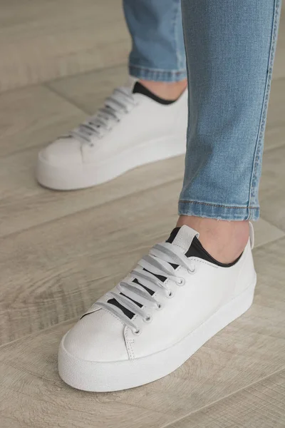 Pieds en jeans et baskets blanches — Photo