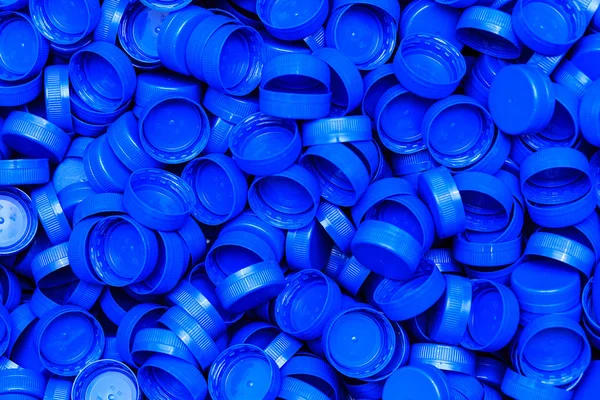 Background of new blue carved plastic caps — Stock Photo, Image