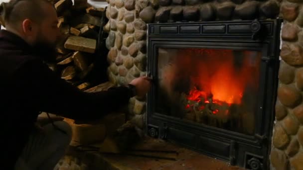 Der Mann Legt Das Holz Den Kaminofen Seines Landhauses — Stockvideo