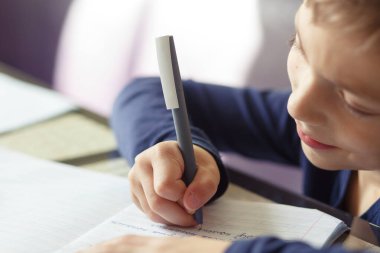 Okul öğretmeni evde eğitim görmekle meşgul. Çocuk bir masada oturuyor, yazıyor, çiziyor ve internetten öğreniyor. Koronavirüs salgınından dolayı karantina, covid-19