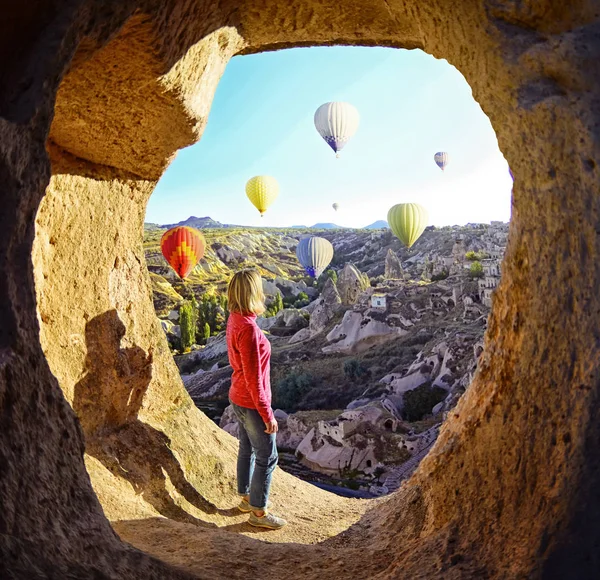 カラフルな熱気球カッパドキア谷上空を飛ぶように見ている女性 — ストック写真