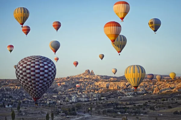 Kleurrijke hete lucht ballonnen vliegen over de vallei in Cappadocië — Stockfoto
